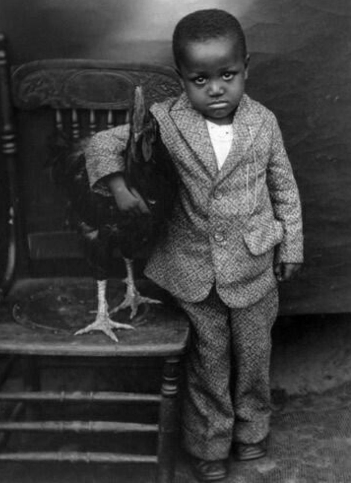 Young boy hugging His Rooster, 1920s